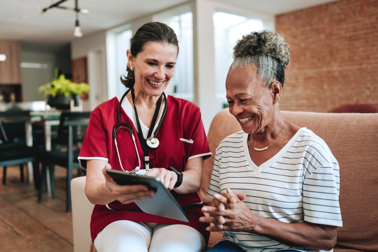 Home healthcare caregiver assisting an older adult in a comfortable home setting.